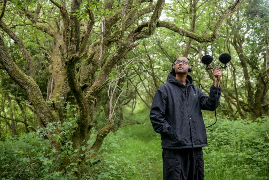 man recording sounds in a forest