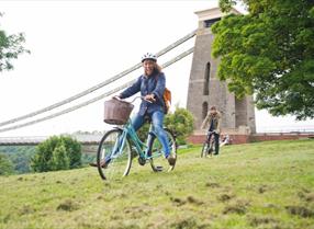 Girl on bike near Suspension bridge