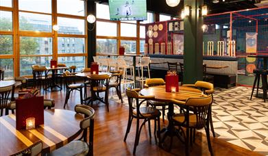 Interior shot of seating, batting cage, and window view of the harbourside