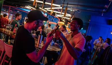 People cheersing bottles of beer