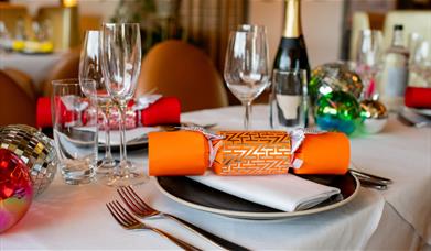 Christmas crackers and decorate table settings, including champagne