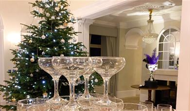 Stacked wine glasses in front of a Christmas tree