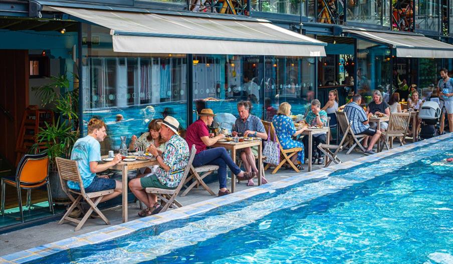People enjoying meal by the pool at Bristol Lido