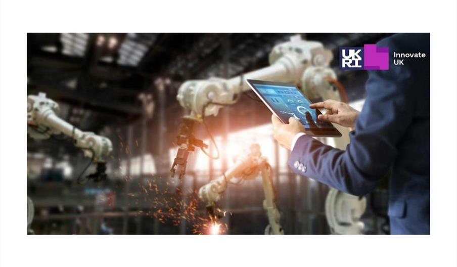 Image of a person using a tablet while robotic arms in the background perform tasks