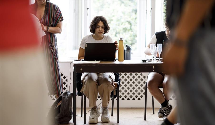 A person sat at a laptop on a table