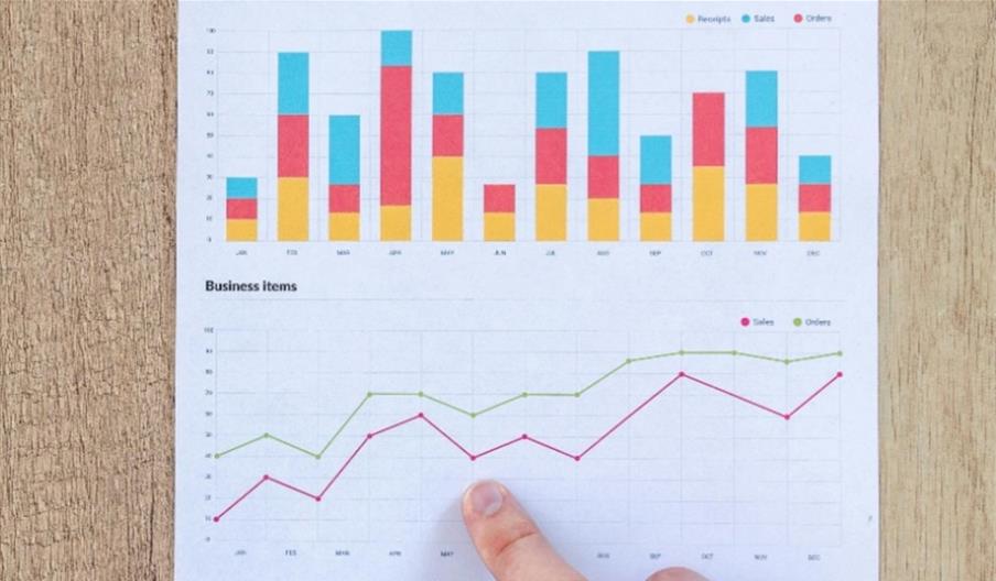 Hand pointing at charts and graphs.