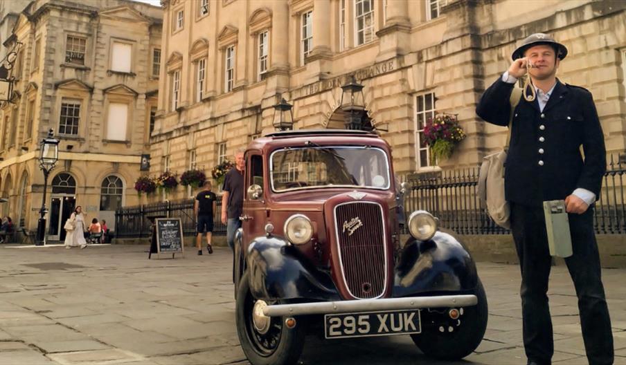 Photo of tour guide next to a classic car in front of St Nicks