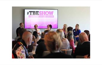 People listening to a panel discussion