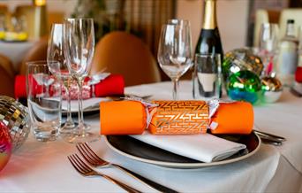 Christmas crackers and decorate table settings, including champagne
