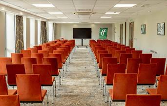 Conference room arranged theatre style seating with a central aisle as seen facing the presenter