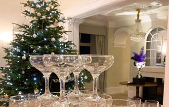 Stacked wine glasses in front of a Christmas tree