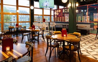 Interior shot of seating, batting cage, and window view of the harbourside