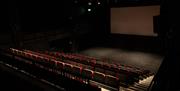 Interior shot of the black box theatre and the screen, as seen from above and from house right, the right side of the venue from the perspective of th