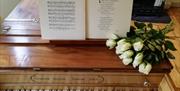 Piano, hymn book, and flowers