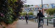 Bicyclers by the harbour looking at rows of coloured houses