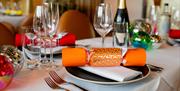 Christmas crackers and decorate table settings, including champagne