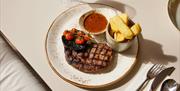 Steak frites with mushroom and tomatoes.