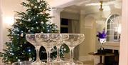 Stacked wine glasses in front of a Christmas tree