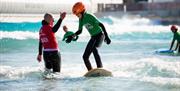 High fiving on a Beginner surf lesson at The Wave