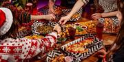 Table of food with people reaching out
