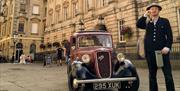 Photo of tour guide next to a classic car in front of St Nicks