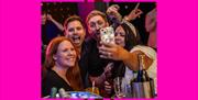 People taking a group selfie at Sixes.