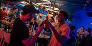 People cheersing bottles of beer