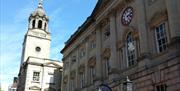 The side of St Nicholas Market in Bristol with the famous clock with two minute hands, showing GMT and Bristol Time.