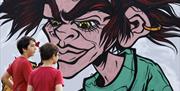 Children walking past street art mural