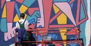 Artist painting a mural as part of Upfest