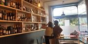 People looking at shelves of bottles