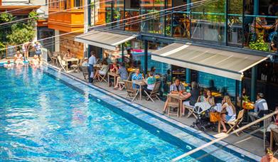 Bristol Lido poolside with people on chairs