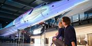 Parent and child looking up at Concorde