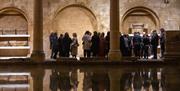 People stood by water's edge at Roman Baths