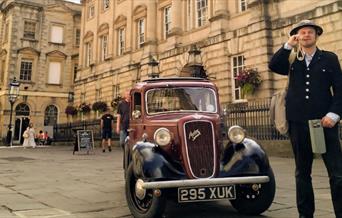 Photo of tour guide next to a classic car in front of St Nicks