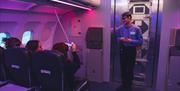 People sat on mock plane in purple light